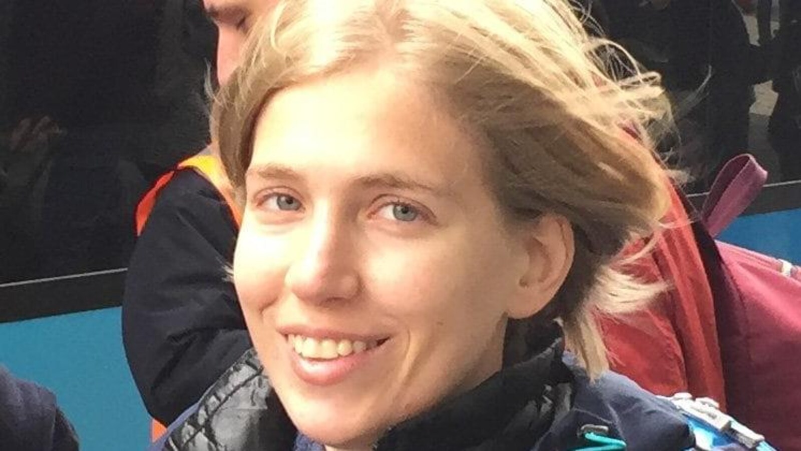 Une jeune femme blonde aux yeux bleus qui sourit.