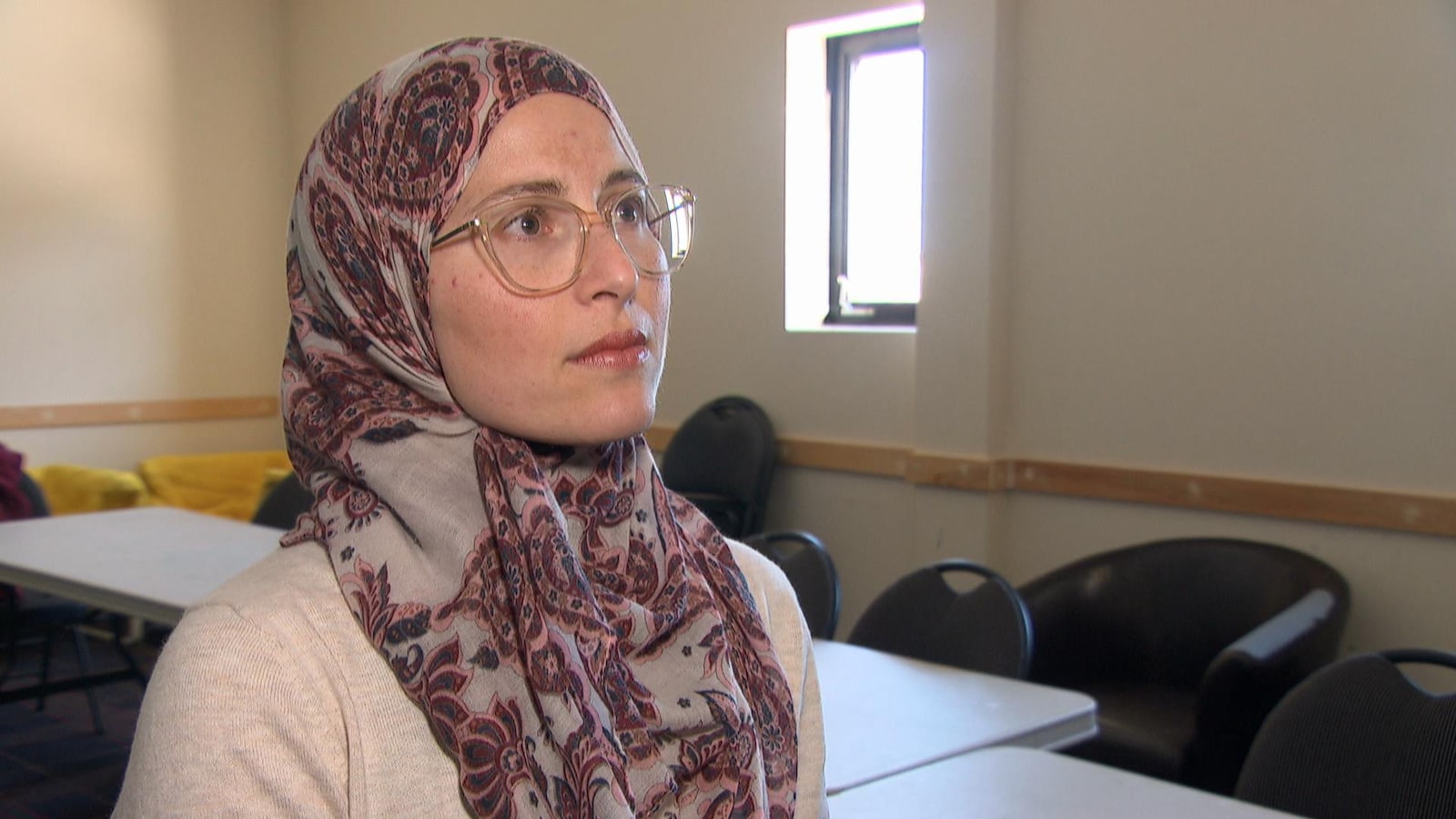 Mme Elghawaby en entrevue dans une salle remplie de chaises et de tables.