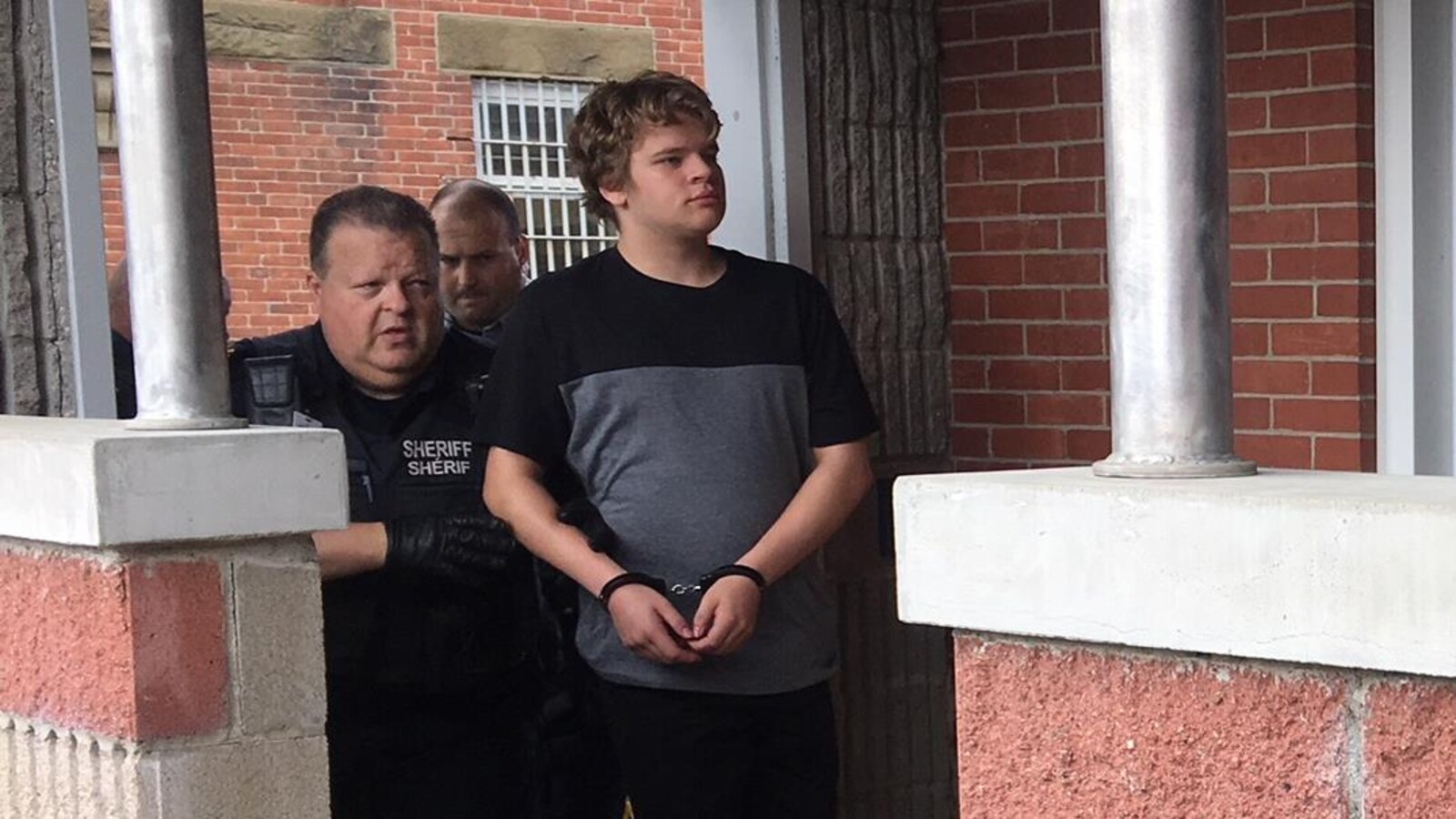 Amon Kelleter menotté accompagné de la police.