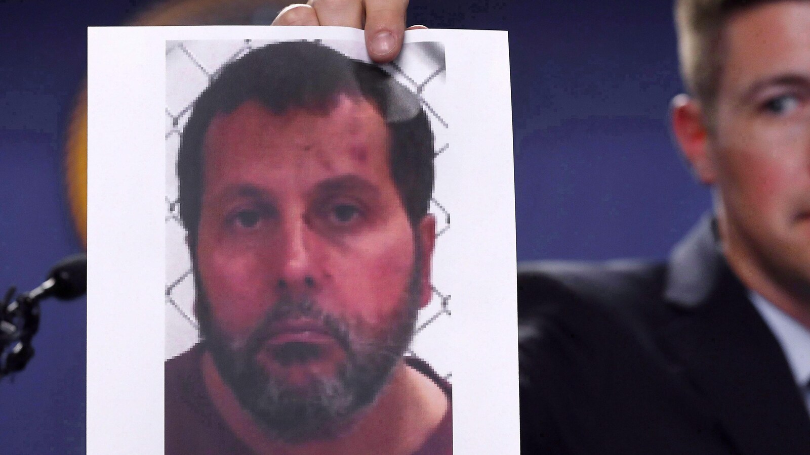 Photo d'Amor Ftouhi présentée par un homme en arrière-plan.