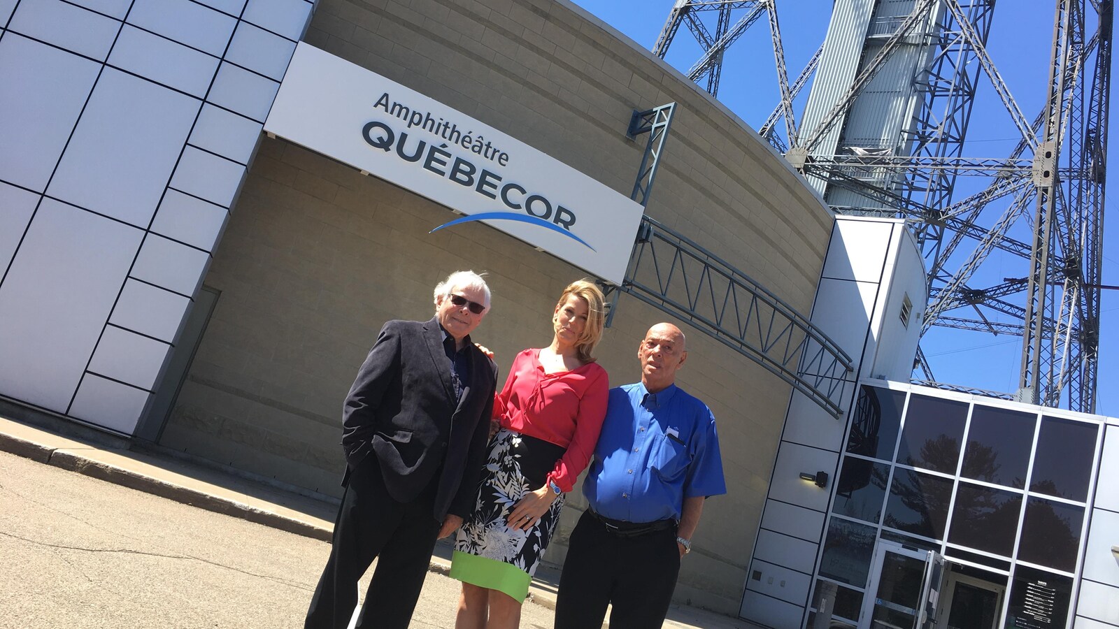 Roland Désaulniers, président du c.a. de la Cité de l’Énergie, Katia Villeneuve, représentante de Québécor, et Robert Trudel, dg de la Cité de l'Énergie, prennent la pose devant l'Amphithéâtre Québécor à Shawinigan.