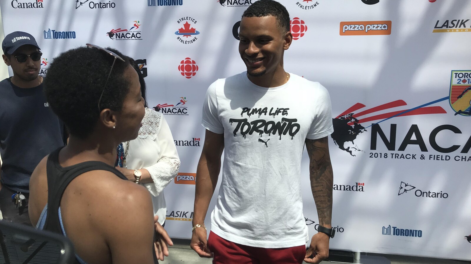 Le sprinteur Andre De Grasse parle à une partisane.