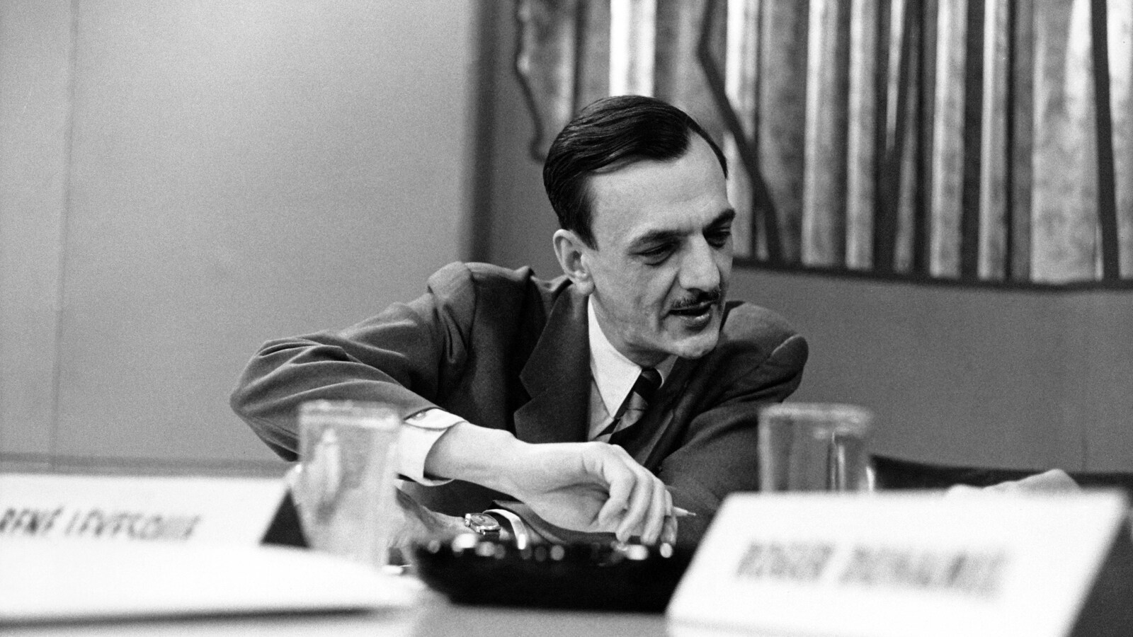 André Laurendeau, crayon à la main, regarde les résultats de l'élection fédérale de 1958.