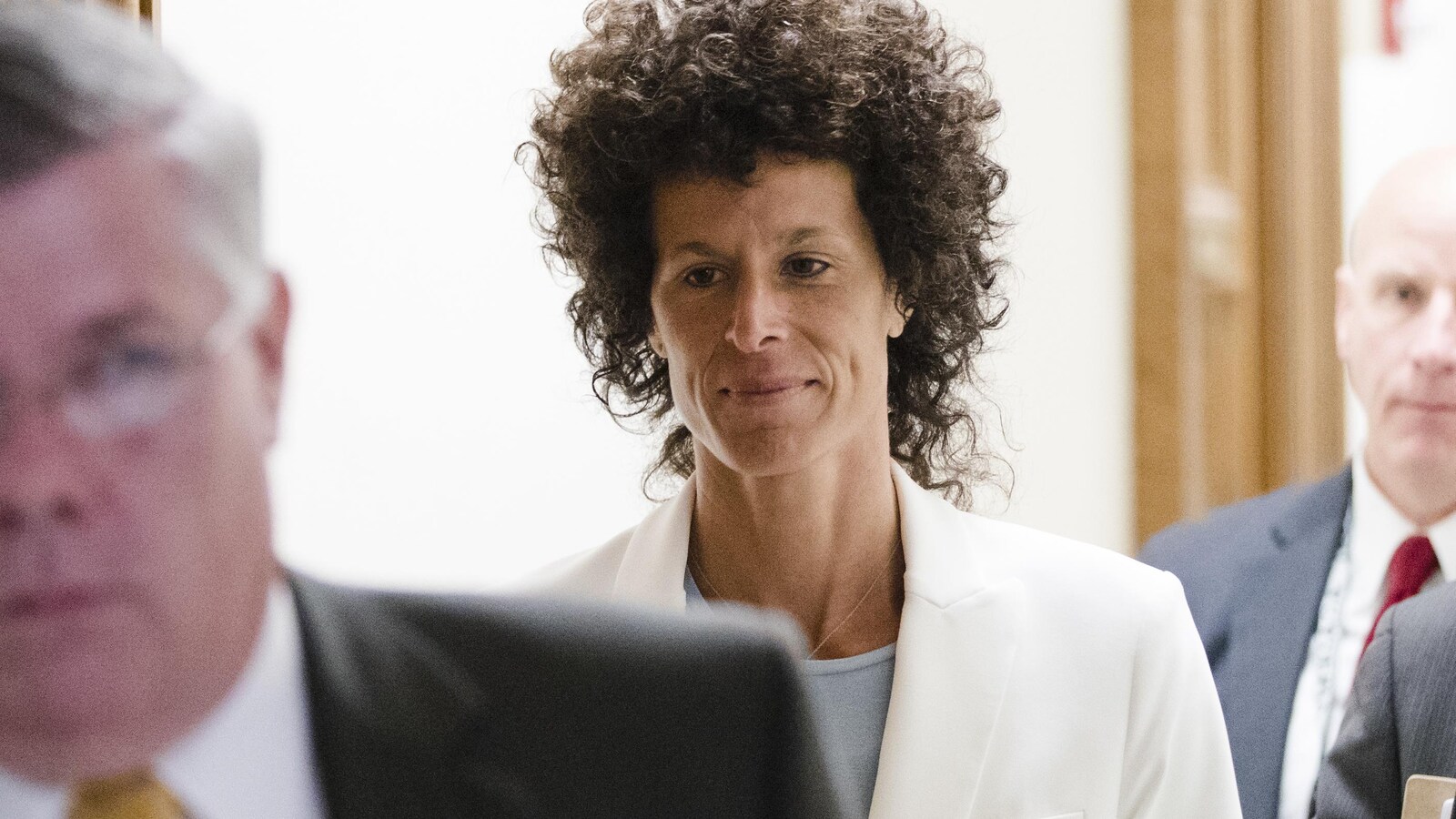 La femme aux cheveux frisés noirs marche dans les couloirs d'un palais de justice en juin 2017.