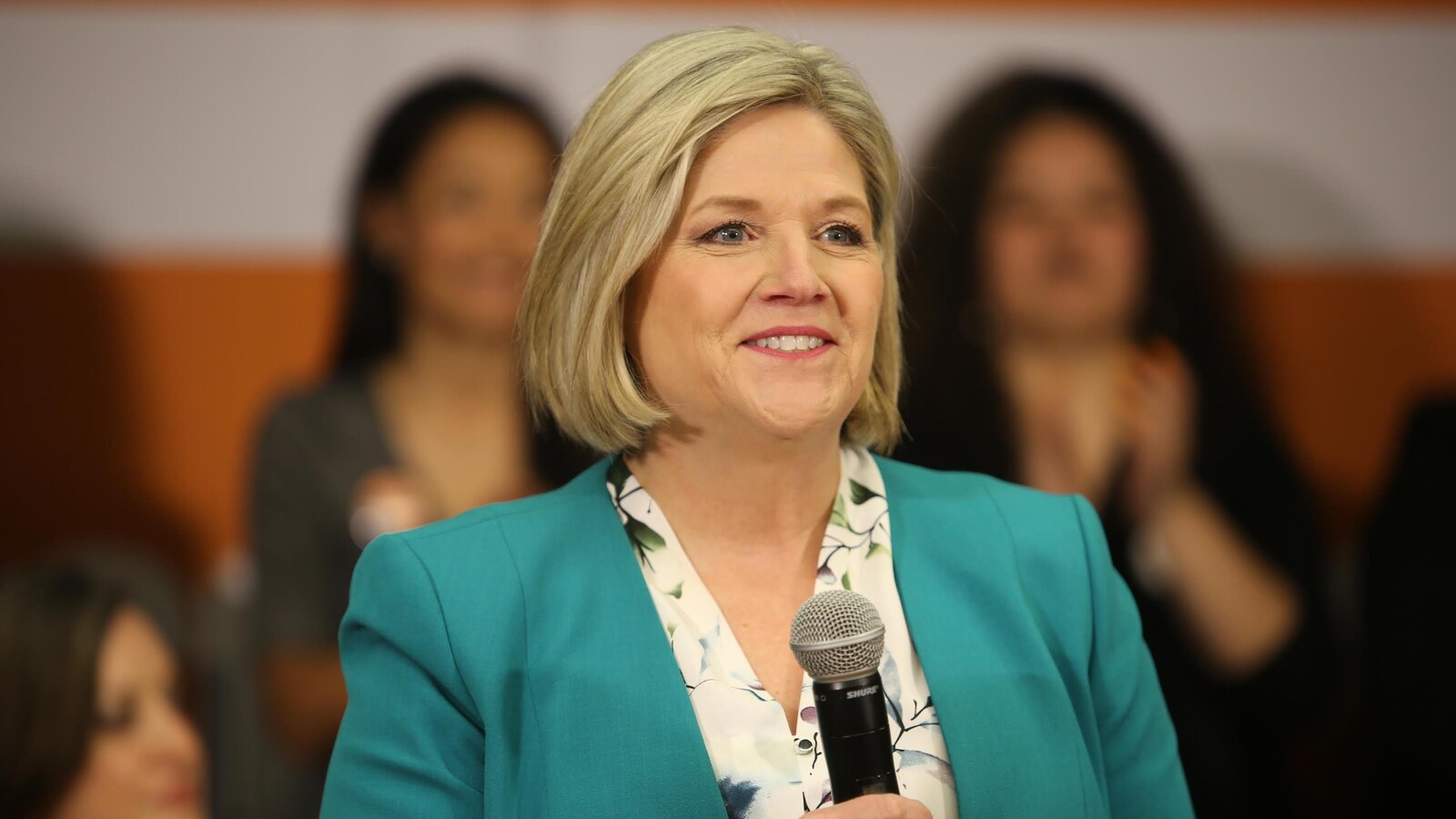 Andrea Horwath debout devant des supporteurs avec un micro à la main.