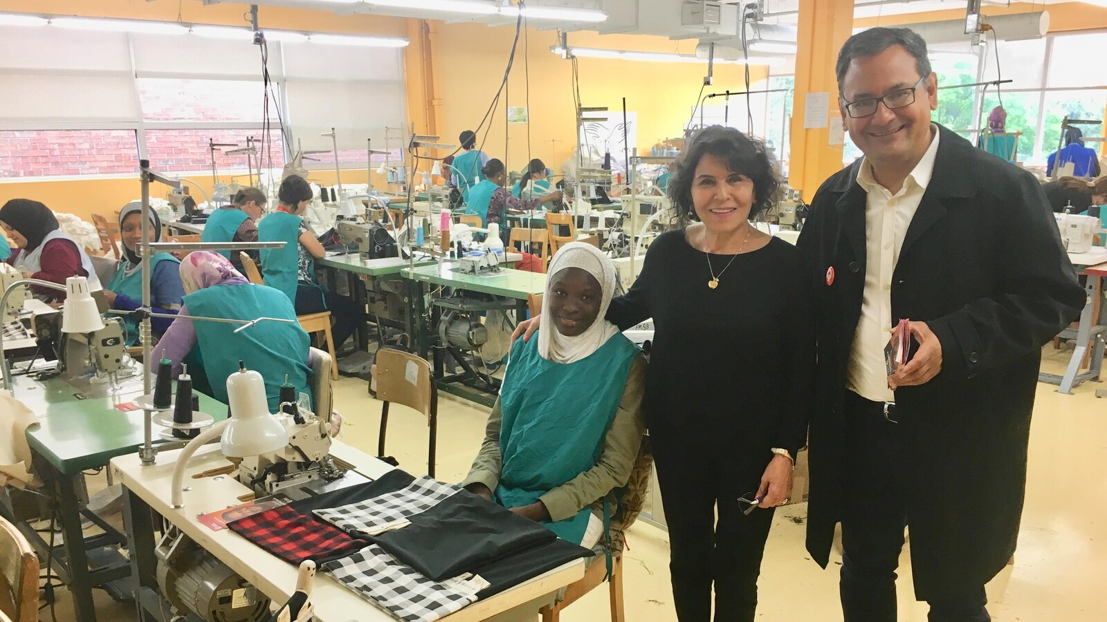 Andrés Fontecilla, Nahif Aboumansour et une travailleuse immigrante posent pour une photo dans les locaux de l'organisme