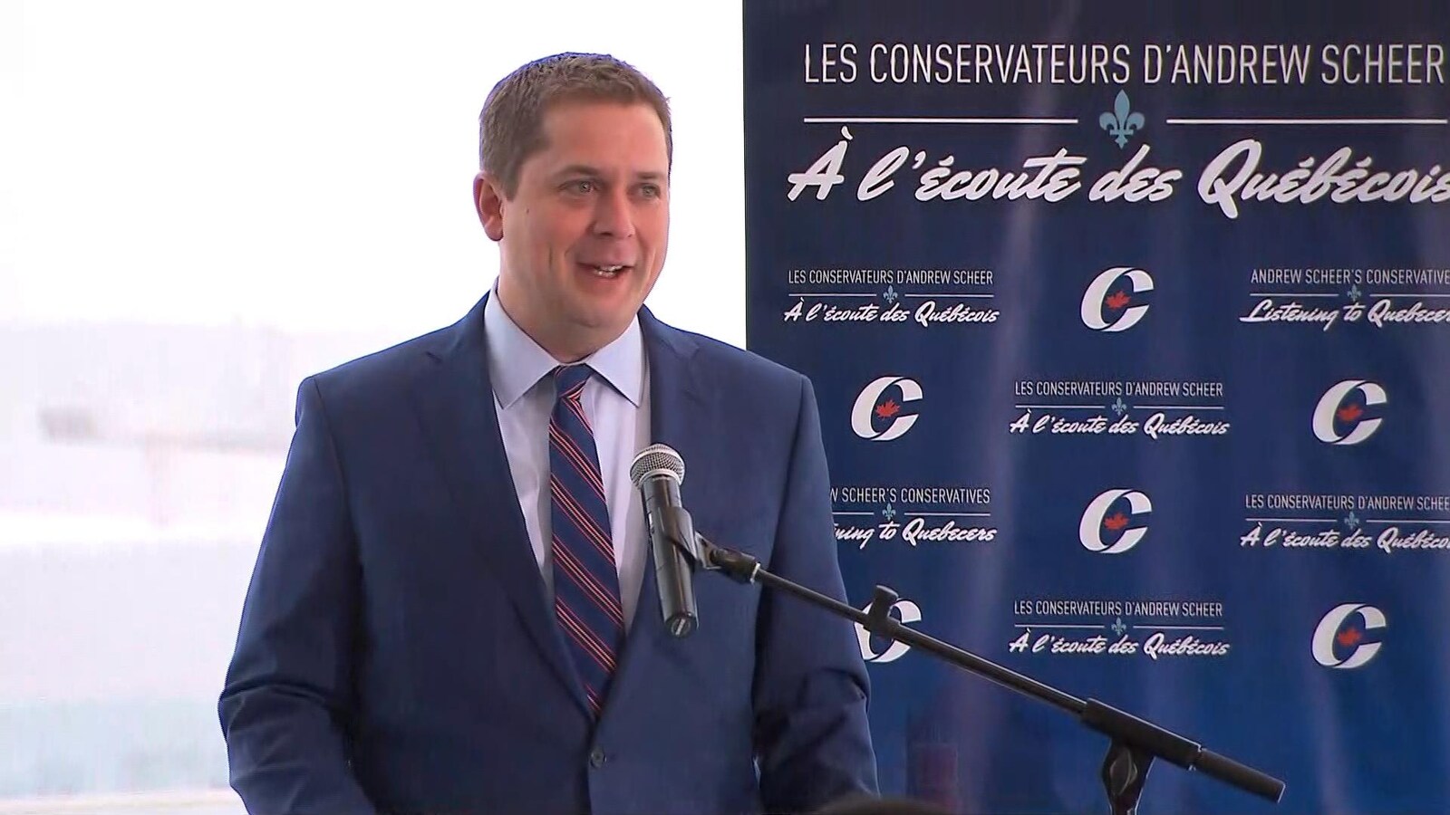 Andrew Scheer, en conférence de presse. « À l'écoute des Québécois », peut-on lire sur une pancarte installée à ses côtés.