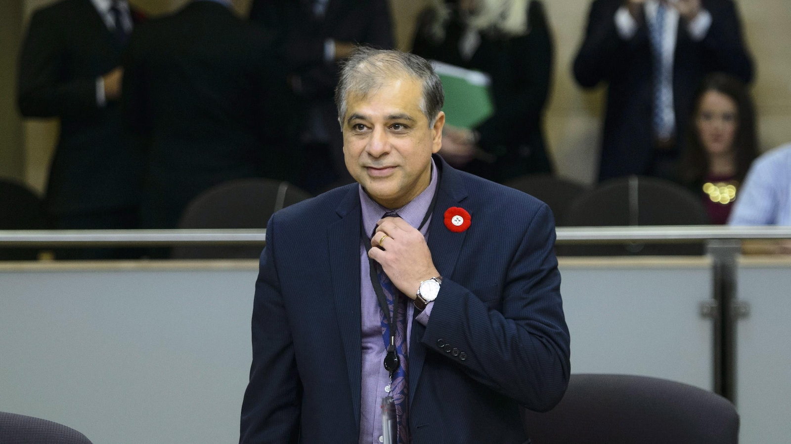 Anil Arora debout, tandis qu'on voit des personnes derrière lui.