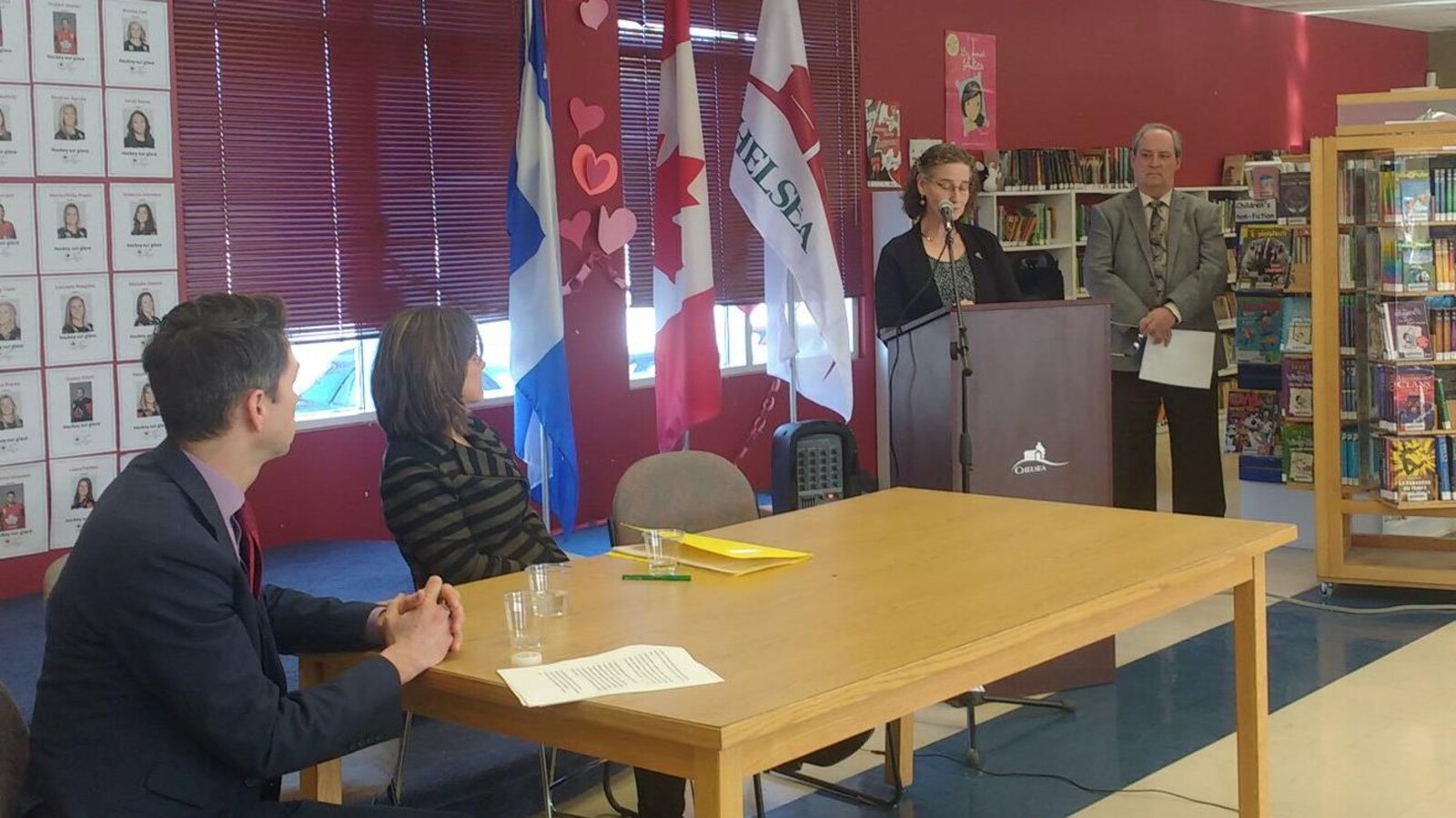 La mairesse est à un podium alors que la ministre responsable de la région à Québec Stéphanie Vallée et le député fédéral de Pontiac Will Amos sont assis à une table