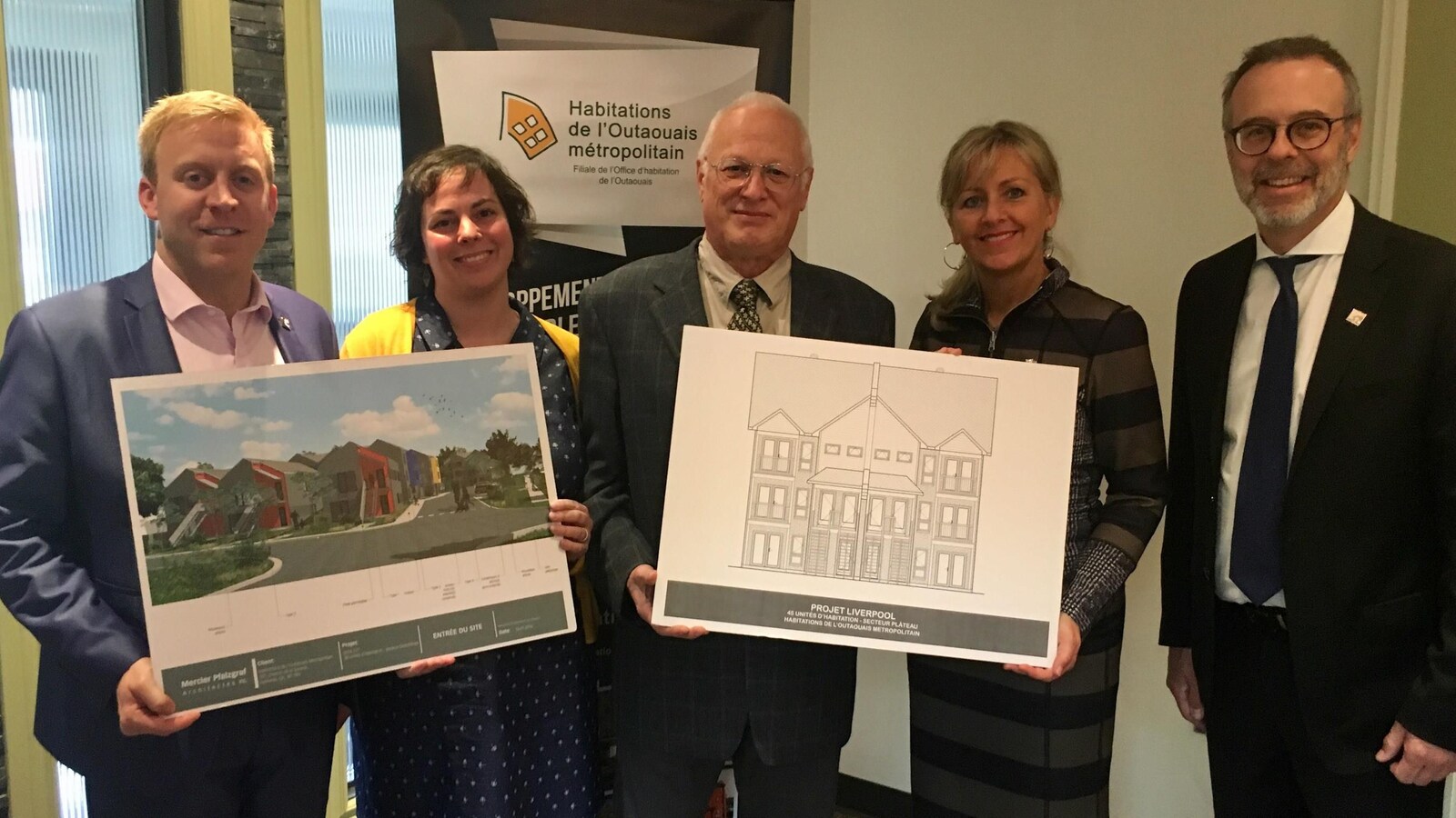 Les représentants montrent en souriant à la caméra les deux maquettes des projets.