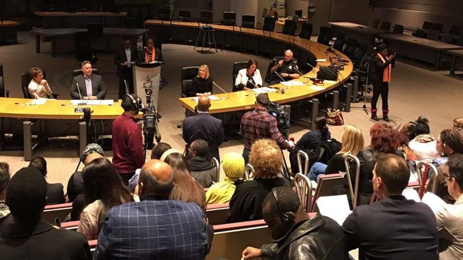 La salle du conseil municipal de la Ville d'Ottawa, avec de nombreuses personnes.