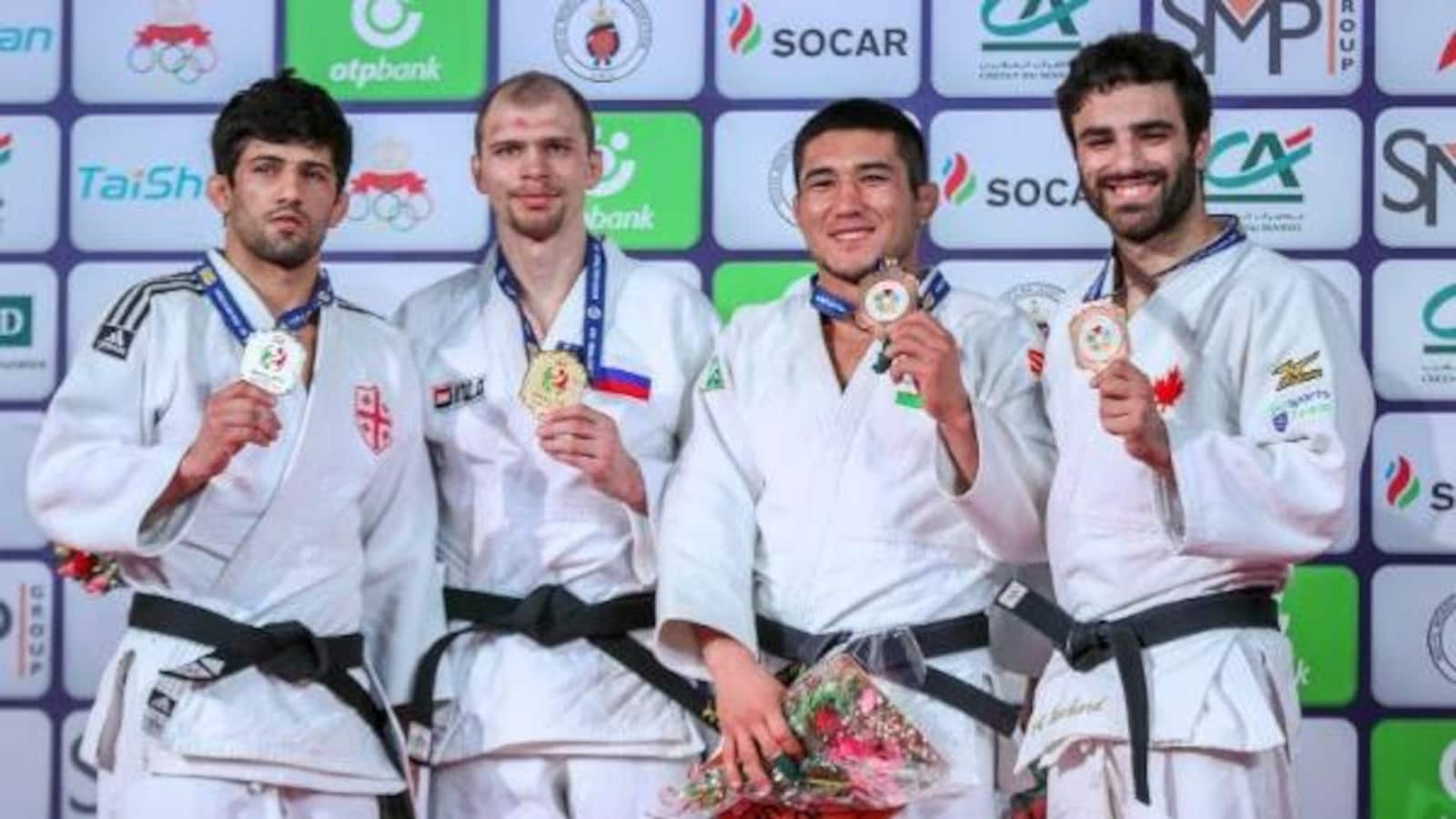 Quatre hommes tiennent leur médaille à la suite de leur victoire. Antoine Bouchard est tout sourire avec le bronze..