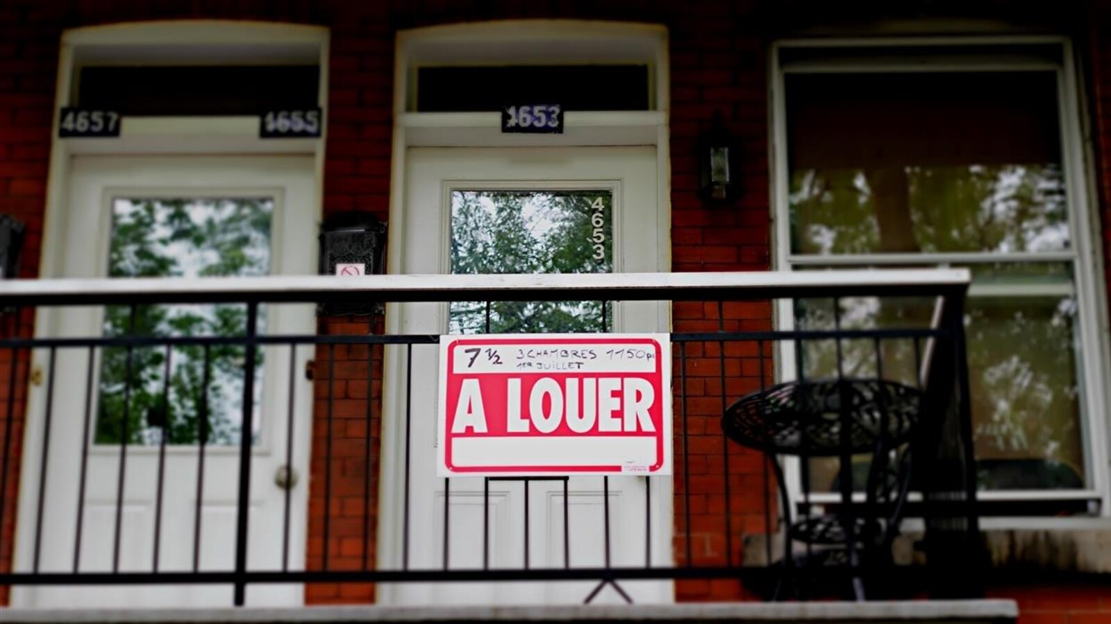 Un immeuble d'appartements à Montréal avec une pancarte À louer devant l'une des portes.