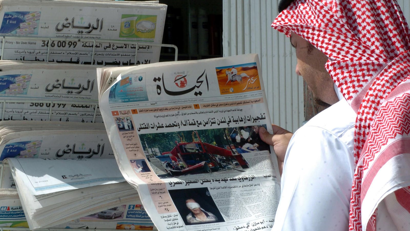Une photo d’archives datant de juillet 2005, montrant un Saoudien qui tient une copie du quotidien Al-Hayat devant un kiosque de journaux dans la capitale Riyad.