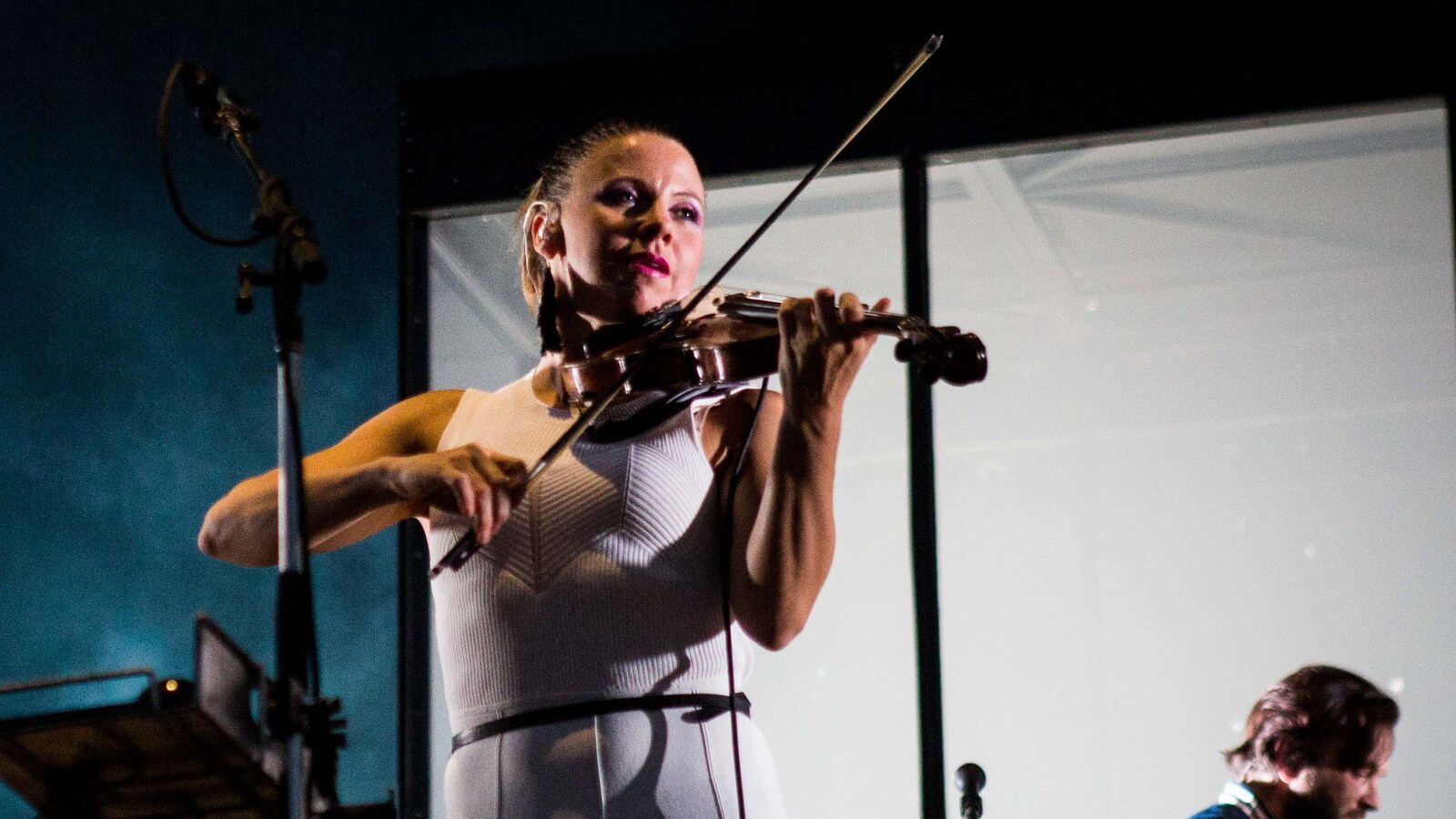 La violoniste du groupe Arcade Fire, Sarah Neufeld, jouant de son instrument sur scène lors d'un spectacle.