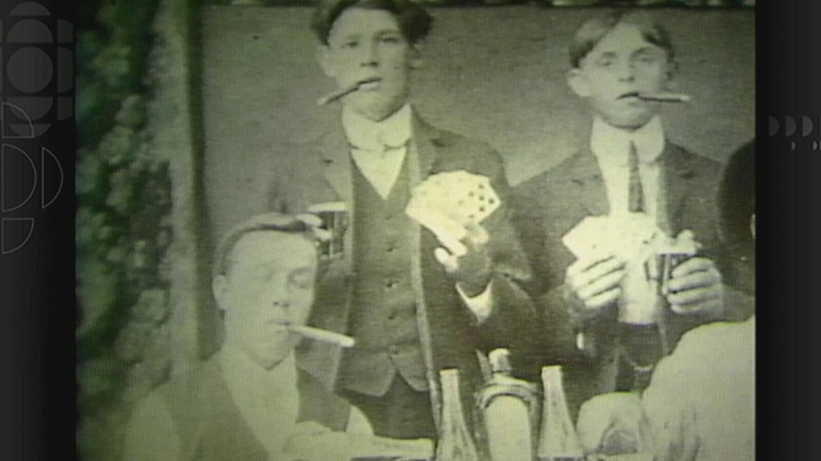 Des jeunes qui fument des cigars et jouent aux cartes