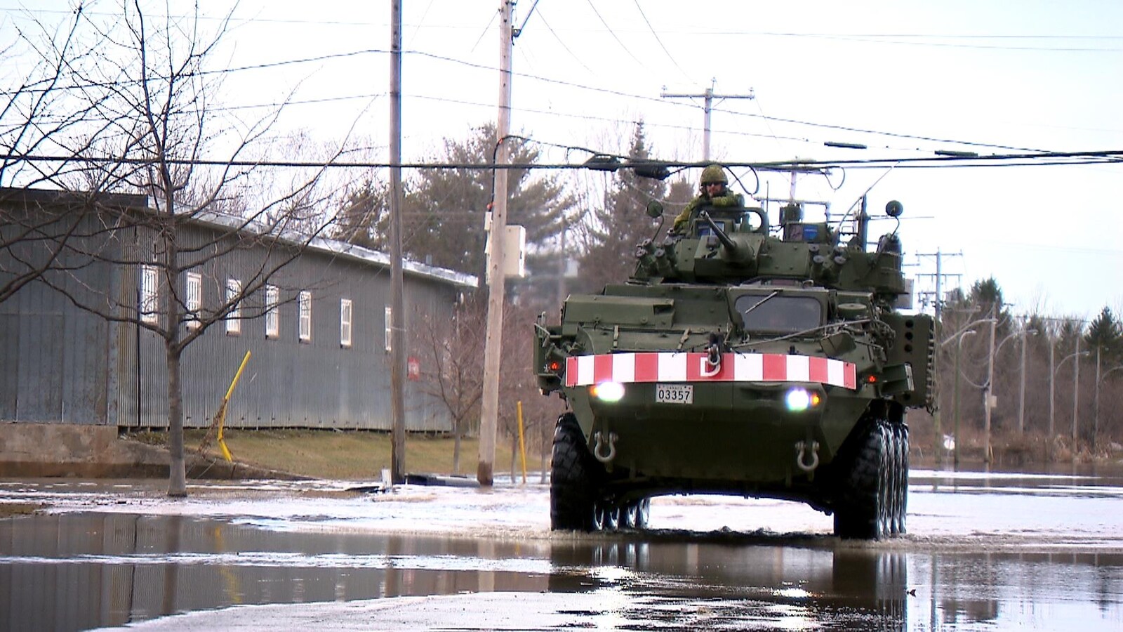 Un véhicule blindé léger circule dans une rue inondée de Sainte-Marie, en Beauce.