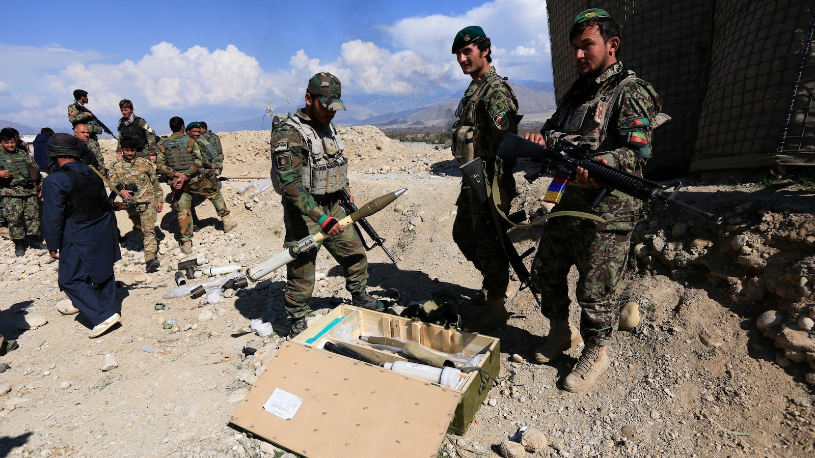 Les soldats de l'armée afghane se tiennent debout, fusils en main et rangent des petits missiles.