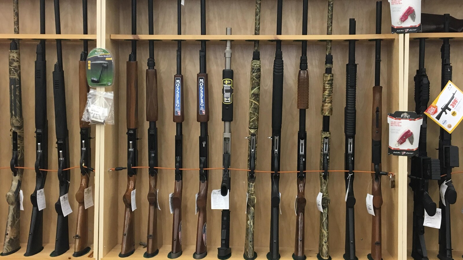 Des armes à feu sont disposées dans une présentoir de magasin.