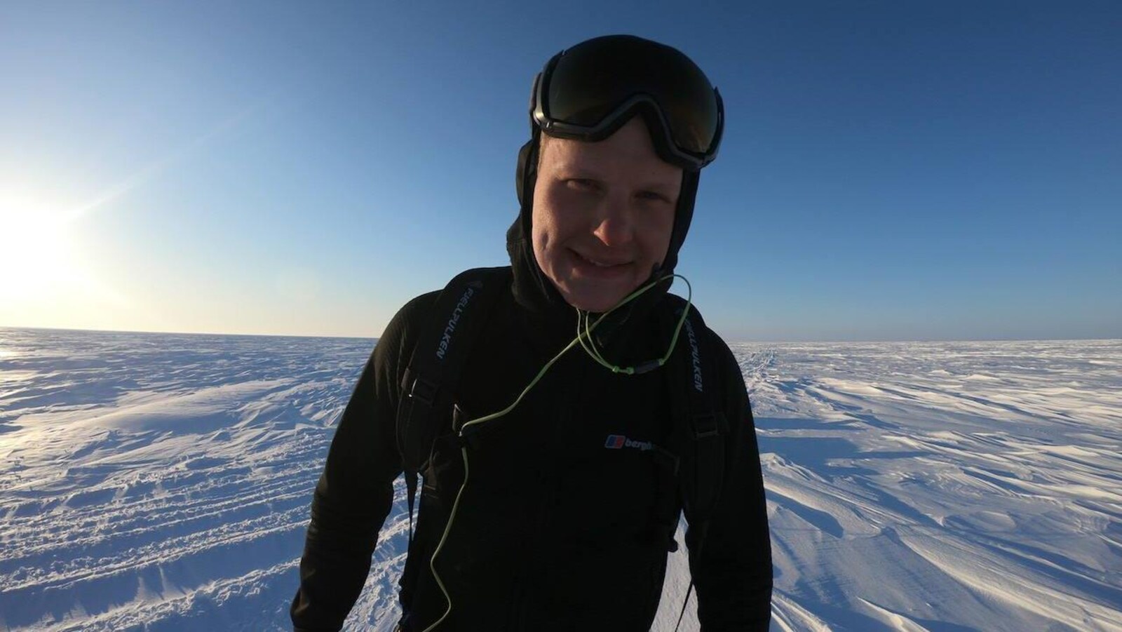 Un homme avec des lunettes de ski debout dans la neige.