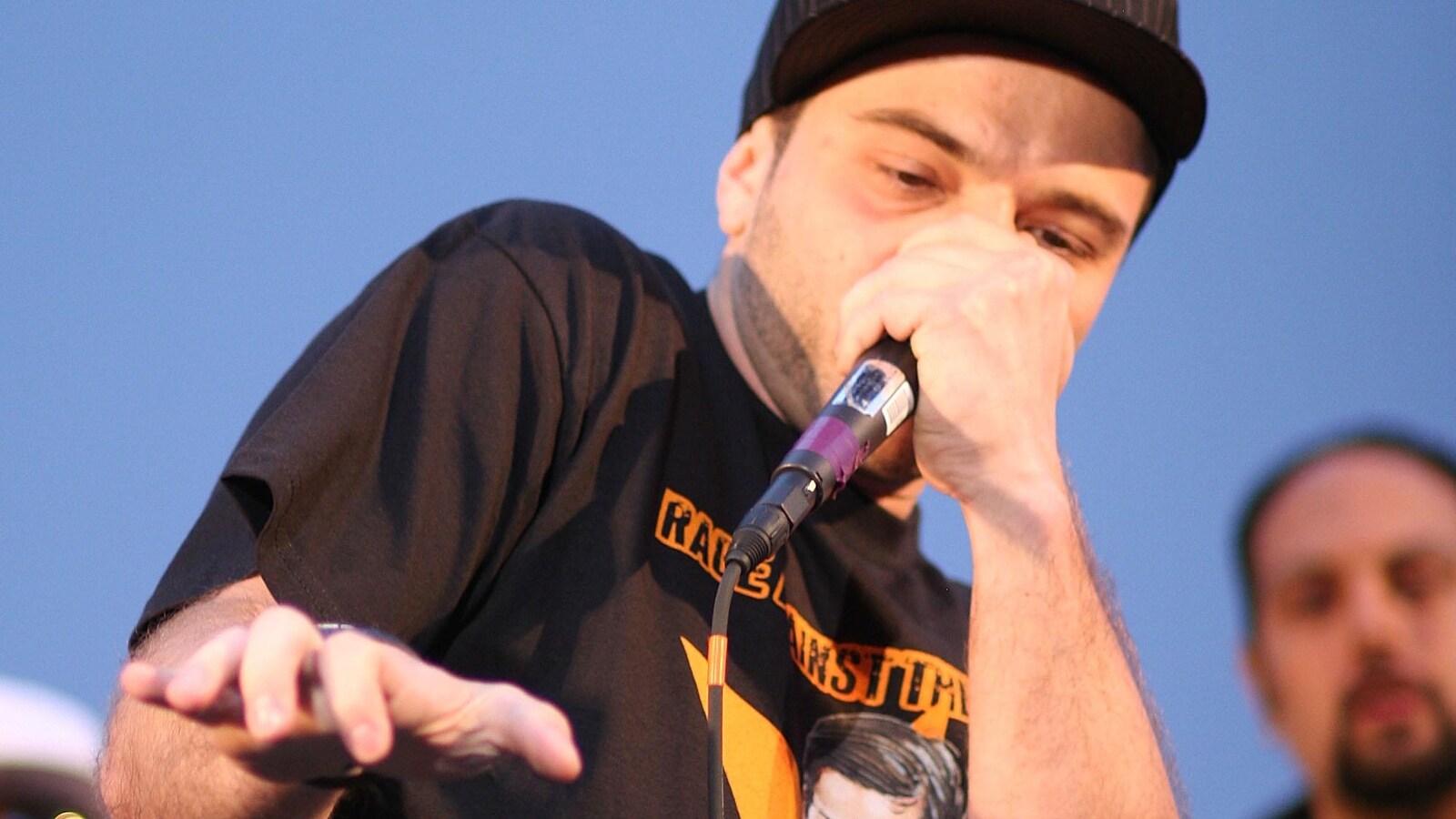 On voit un homme, de face, muni d'un micro en train de faire du beatbox.