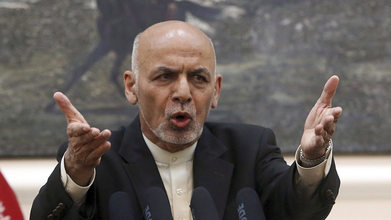 Ashraf Ghani, les bras tendus devant lui, parle dans des micros.