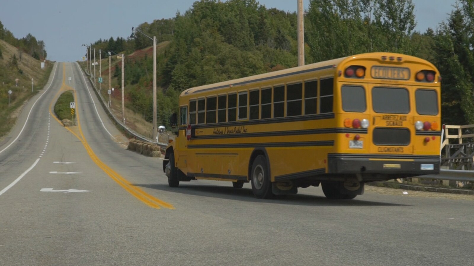 Un autobus scolaire monte la côte des Éboulements.