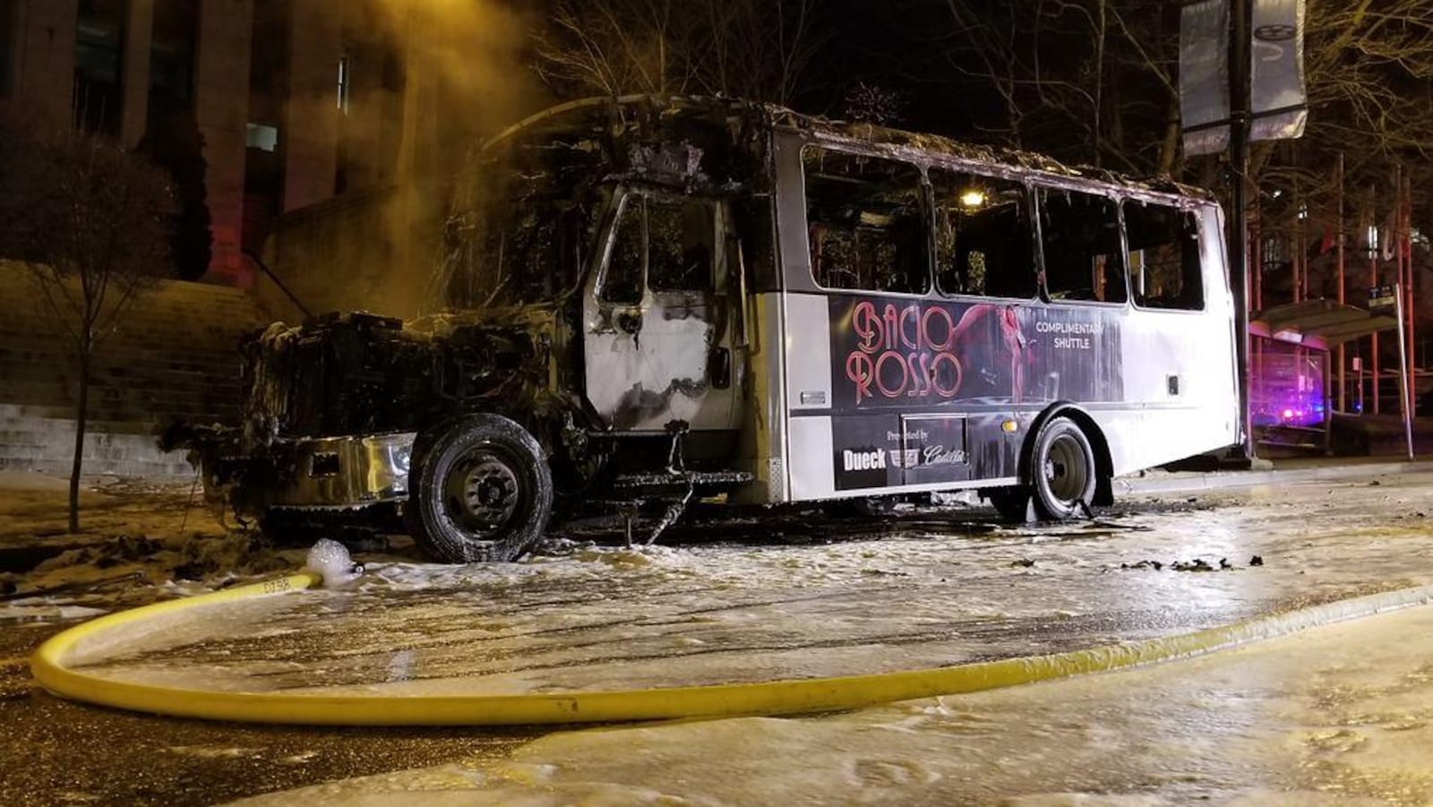 De la fumée sort du moteur de l'autobus calciné et garé devant des marches de l'hôtel de ville de Vancouver.