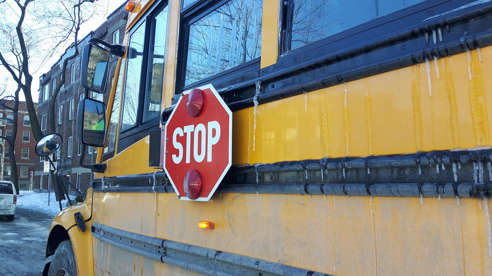 Un autobus scolaire arrêté dans un quartier résidentiel.
