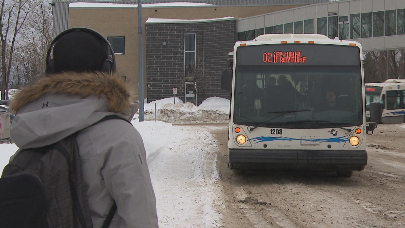 Un étudiant attend l'autobus.