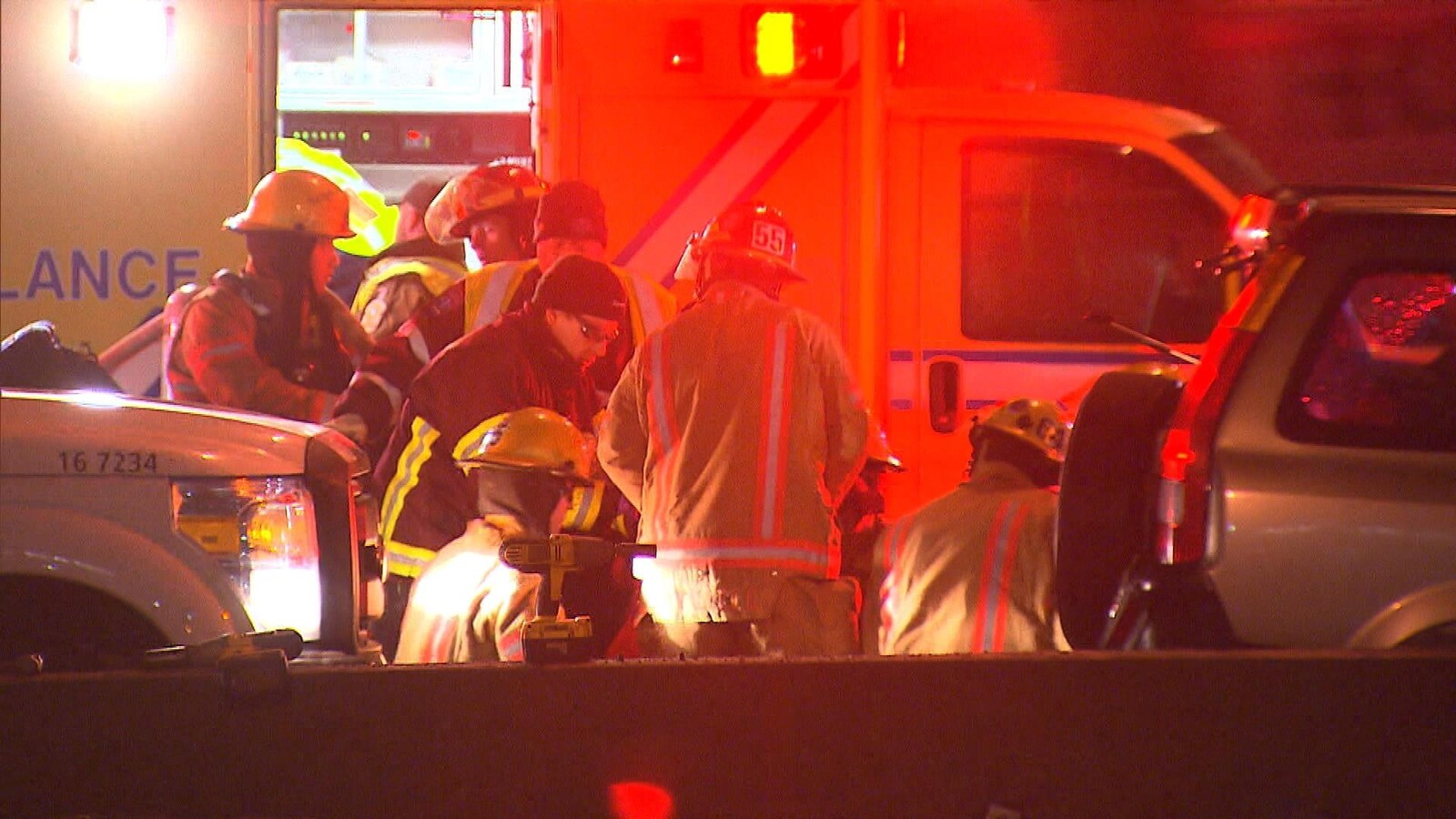 Des pompiers et des ambulanciers s'affairent devant une ambulance.