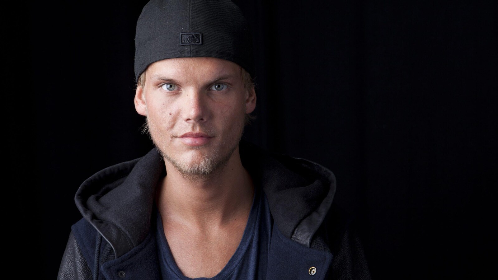 Le DJ d'origine suédoise Avicii prend la pose avec un sourire enigmatique.