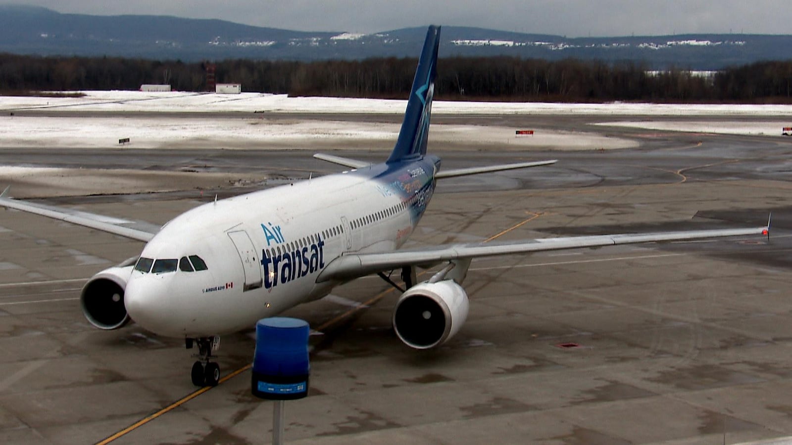 Un appareil de la compagnie Air Transat photographié en hiver sur le tarmac de l'aéroport de Québec.