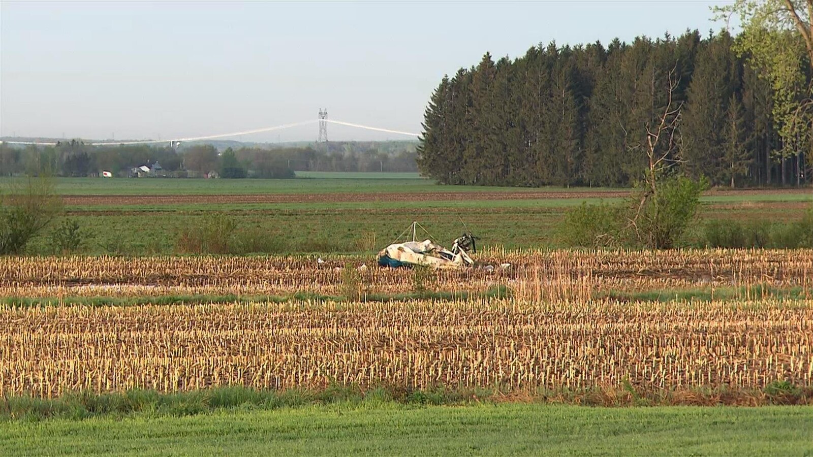 Une carcasse d'avion au cœur d'un champ à l'aube.