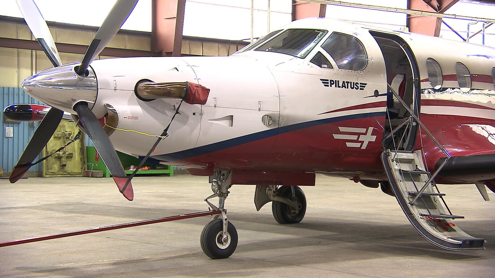 Un avion Pilatus PC12, sur le tarmac, l'escalier qui mène à l'intérieur de l'appareil, déployé
