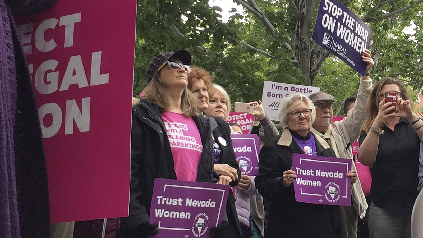 Des femmes tiennent des affiches dans leurs mains devant le parlement.