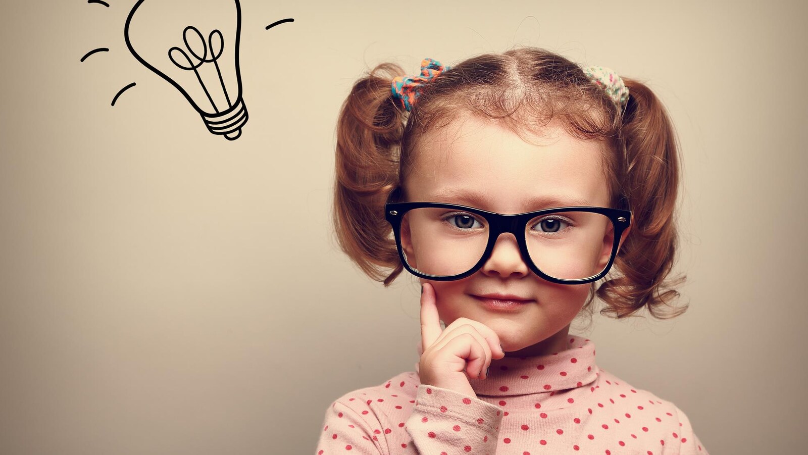 Une fillette avec des lunettes et une ampoule dessinée au-dessus de la tête.