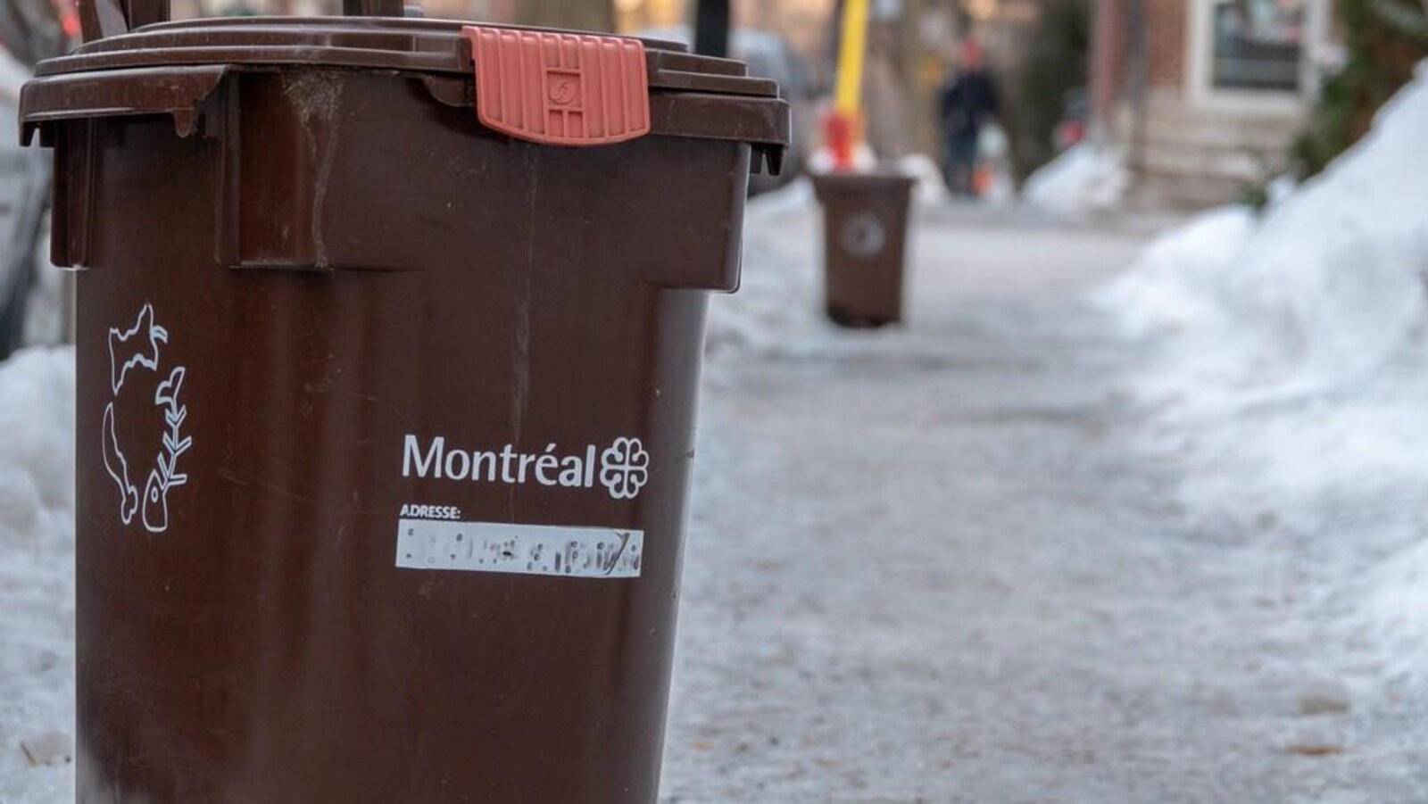 Un bac brun en bordure de la rue, en hiver.