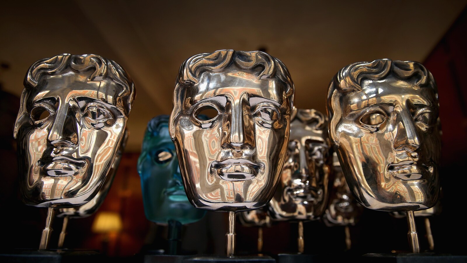 Des trophées dorés en forme de masques.