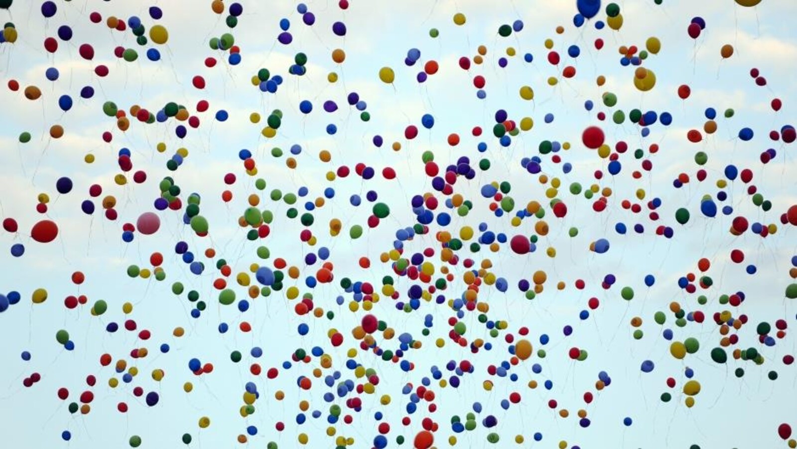 Une nuée de ballons gonflés à l'hélium dans le ciel.