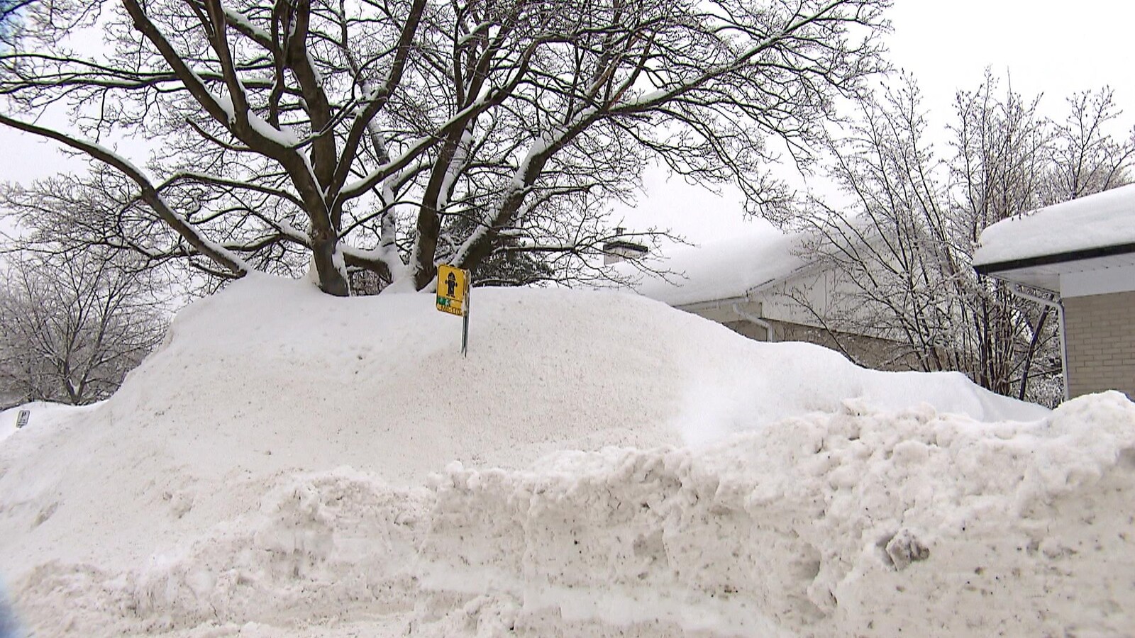 Une maison partiellement dissimulée par un banc de neige dans un quartier résidentiel de l’arrondissement Sainte-Foy–Sillery–Cap-Rouge, à Québec.