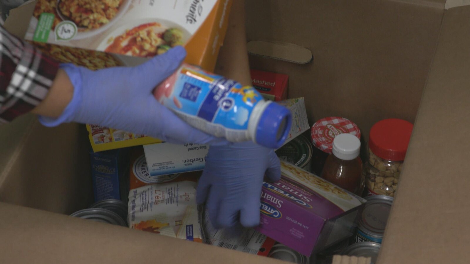 Des bénévoles vident une boîte de denrées dans une banque alimentaire de Toronto.