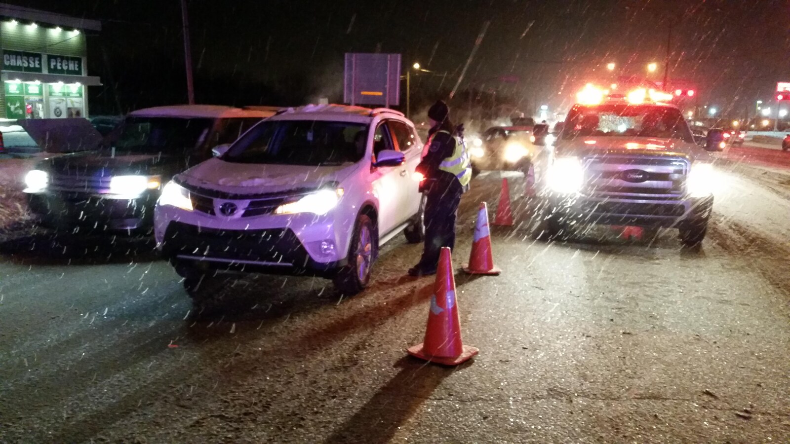 Un policier s'adresse à un automobiliste pendant un barrage routier.