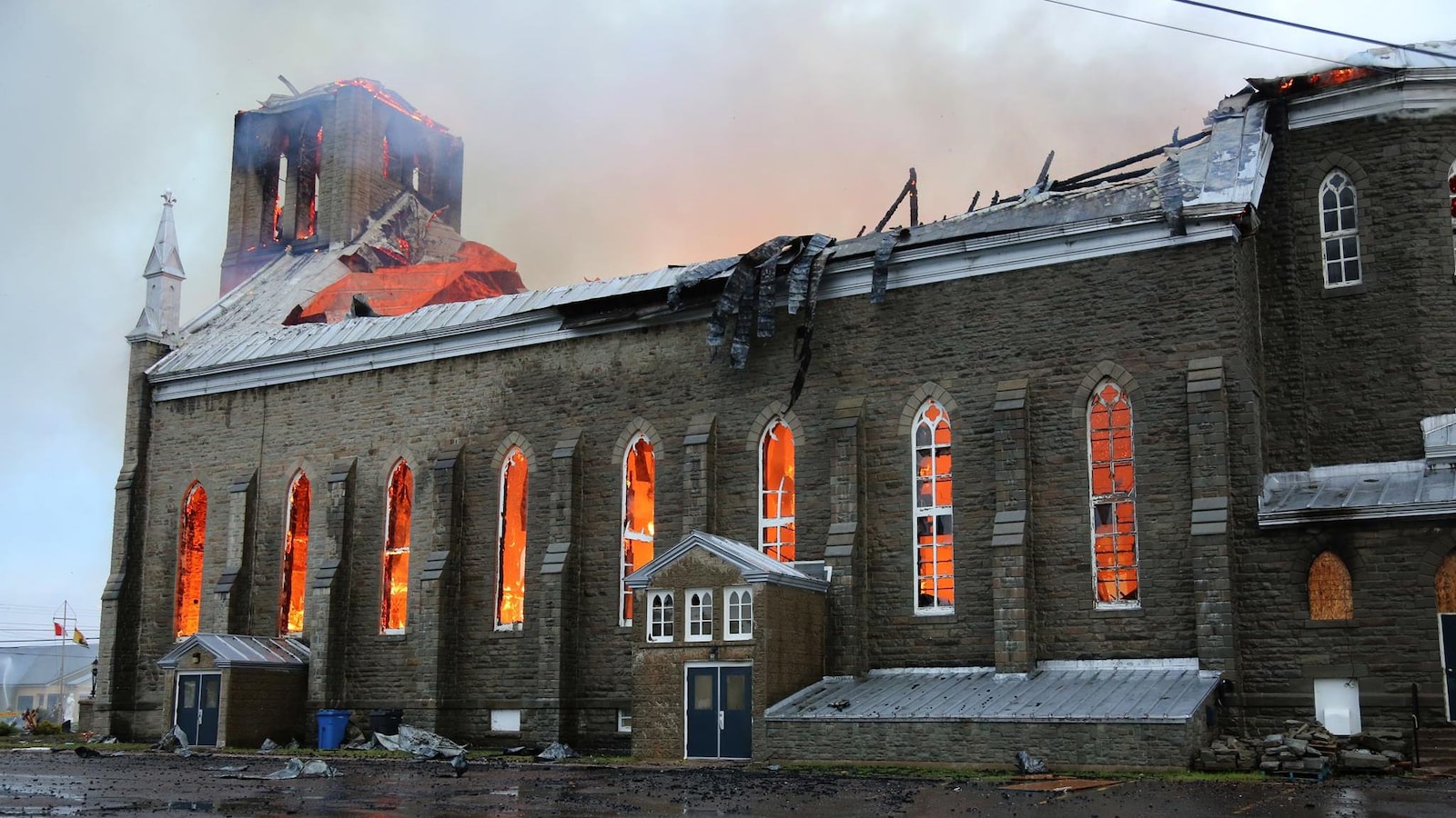 La lueur des flammes éclaire l'intérieur de l'église en ruine.