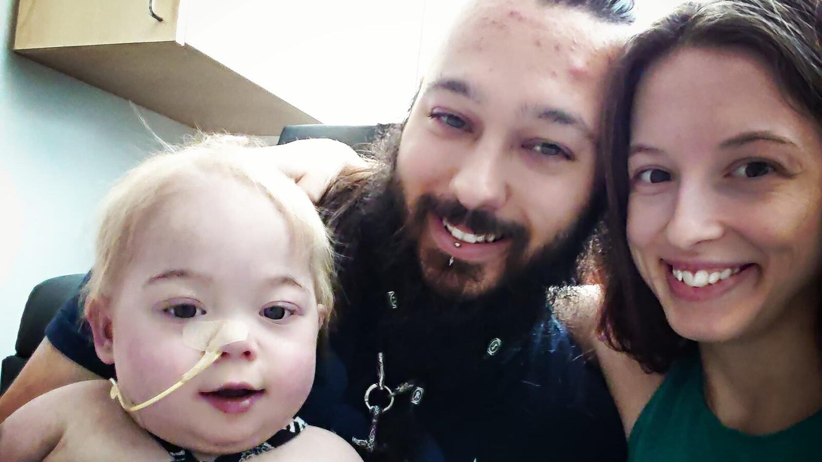 Des parents posent avec leur bébé intubé dans un hôpital.