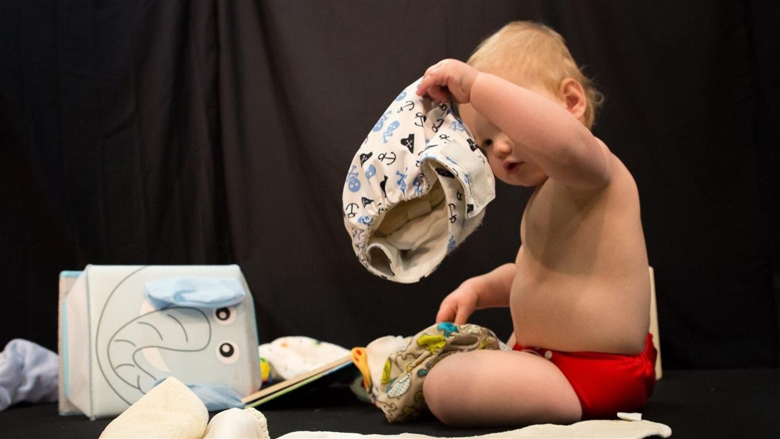 Un bébé tient une couche lavable.