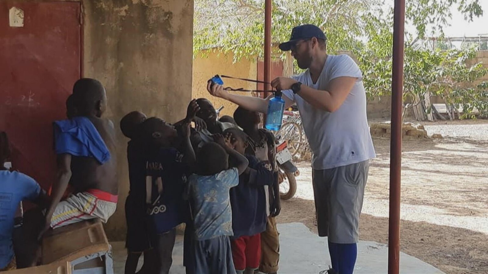 Un Québécois qui montre un appareil photo à des enfants