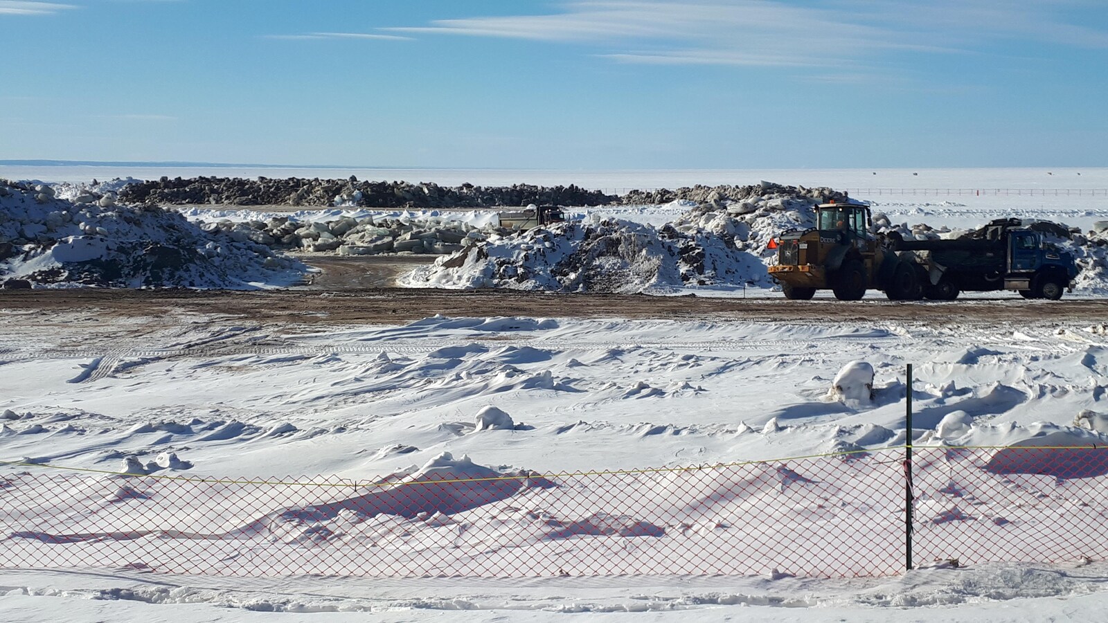 Chantier hivernal avec camions en hiver sur les rives du lac Saint-Jean.
