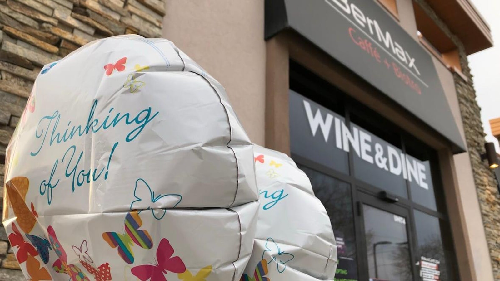 Des ballons avec des messages de soutien devant l'entrée du restaurant BerMax.