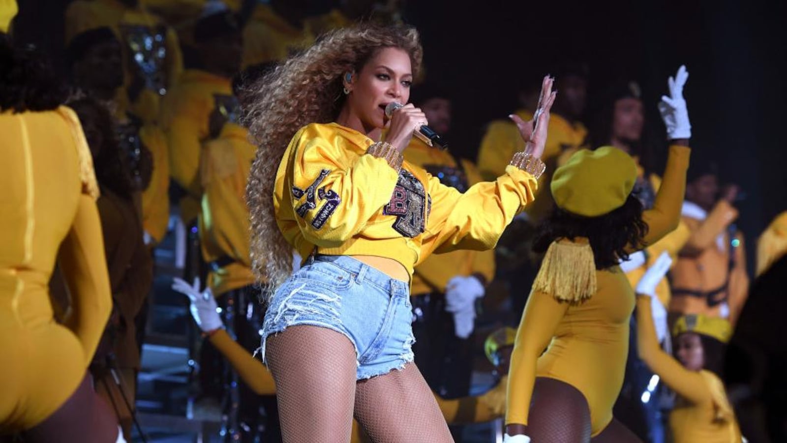 Beyoncé chante sur scène entourée de ses danseuses.